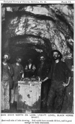  Historic photo of miners standing in a wide underground tunnel at the Black Horse shaft at the 1,730-ft level.