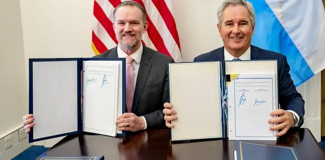 Panorama Minero article showing US and Argentine officials holding signed agreement documents on critical minerals investment.