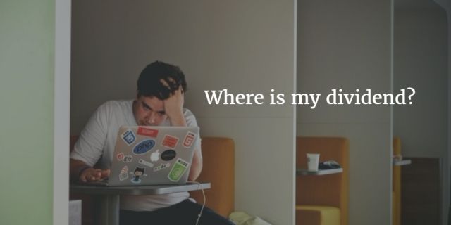 Man sitting with laptop looking frustrated, holding his head, with text overlay reading “Where is my dividend?”