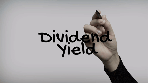 Hand writing the words “Dividend Yield” with a marker on a transparent surface against a plain background.
