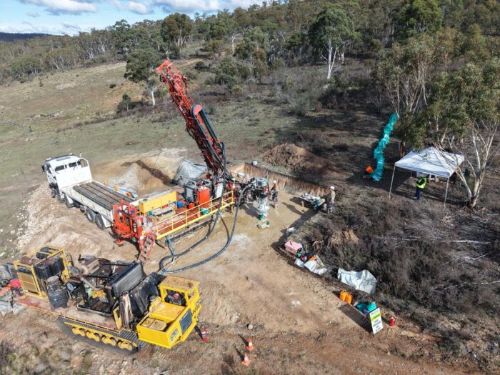 Aerial view of a drill rig and support crew operating at Exultant Mining’s Balerion Prospect, surrounded by bushland and exploration infrastructure.