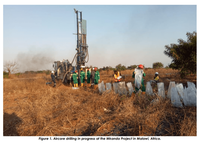 Aircore drill rig operating at the Mkanda Project in Malawi as field crew collect and bag drill samples beside the rig.