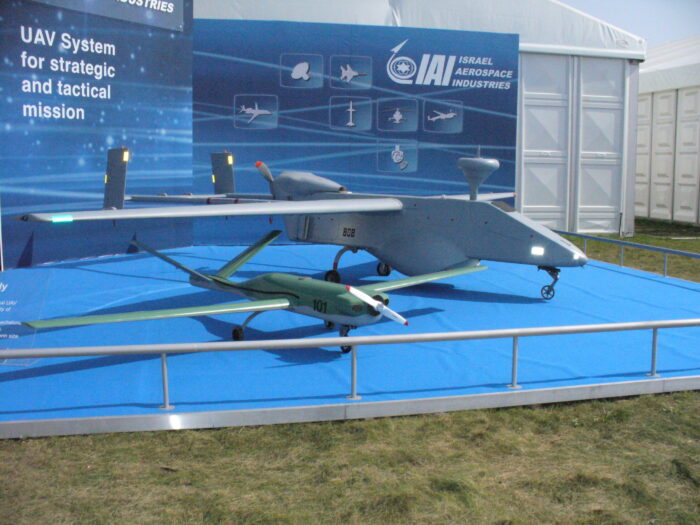 Two unmanned aerial vehicles on display at an Israel Aerospace Industries exhibition showcasing strategic and tactical UAV systems.