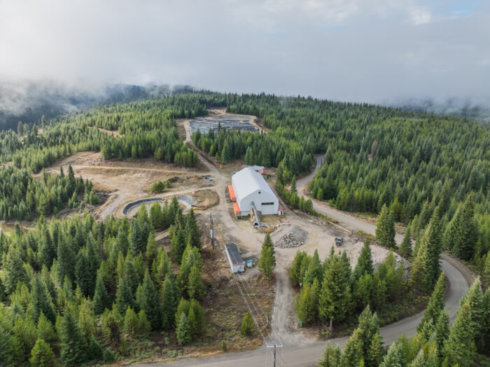 Aerial view of the Friday Gold Mine site in Idaho, showing processing facilities surrounded by forest and access roads.