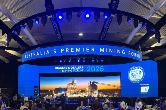 Stage at the 2026 Diggers & Dealers Mining Forum, with large blue screens promoting Australia's premier mining event.