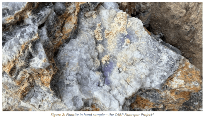 Close-up of fluorite mineralisation in a hand sample from the CARP Fluorspar Project, showing white quartz with purple fluorite.