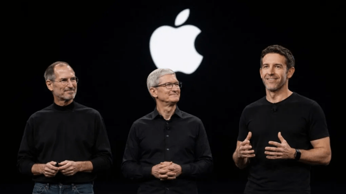 Three Apple executives on stage beneath a large Apple logo during a company presentation.